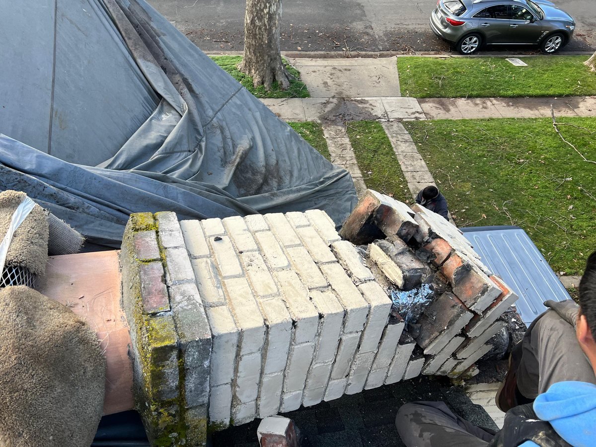 Replacement block and brick staged on the roof for a chimney rebuild