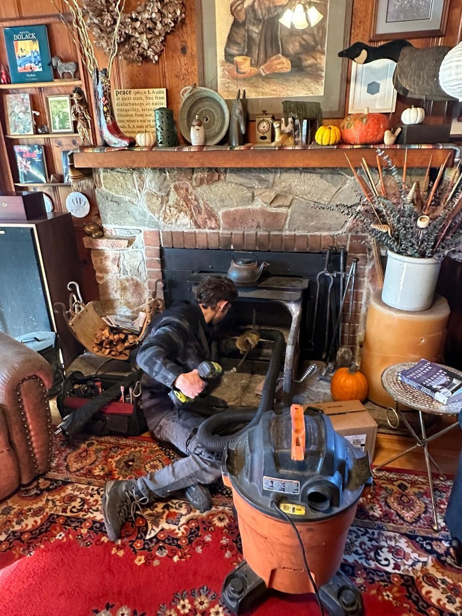 Chimney sweep underway in a furnished living room with the floor fully covered