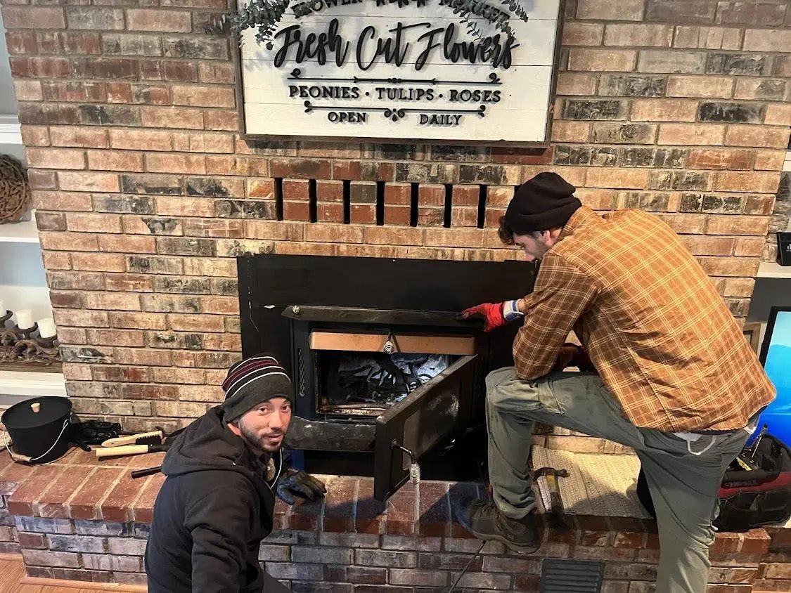 Two technicians working on a brick firebox