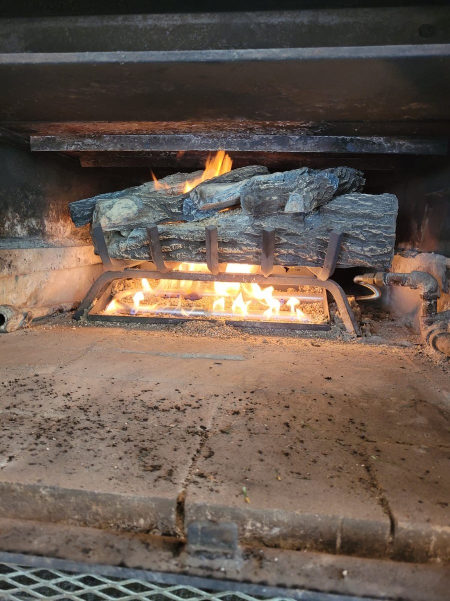 Gas log set burning in a firebox before servicing