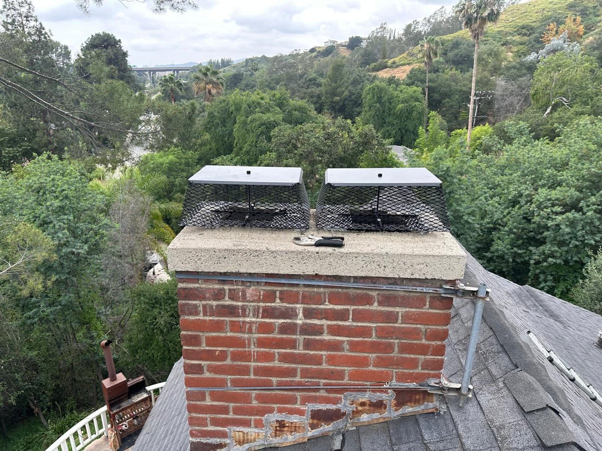 Brick chimney fitted with two stainless flue caps